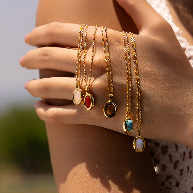 Gold medallion necklaces held in natural light
